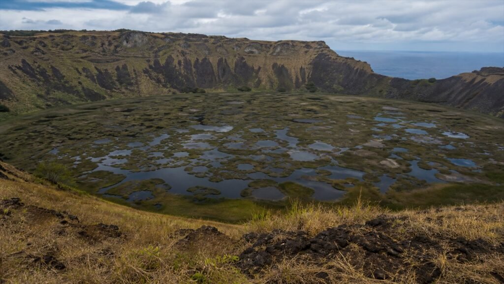 فوهة Rano Kau ومسطحها النباتي والماء تحت غيوم محيطية متحركة